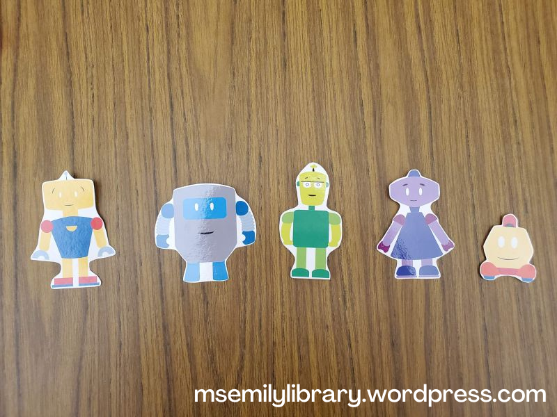 Printed and laminated photos of five robots in different colors and with different body types.