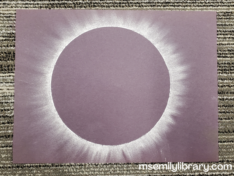 Picture of the chalk eclipse craft, showing the corona of the sun behind a black moon.